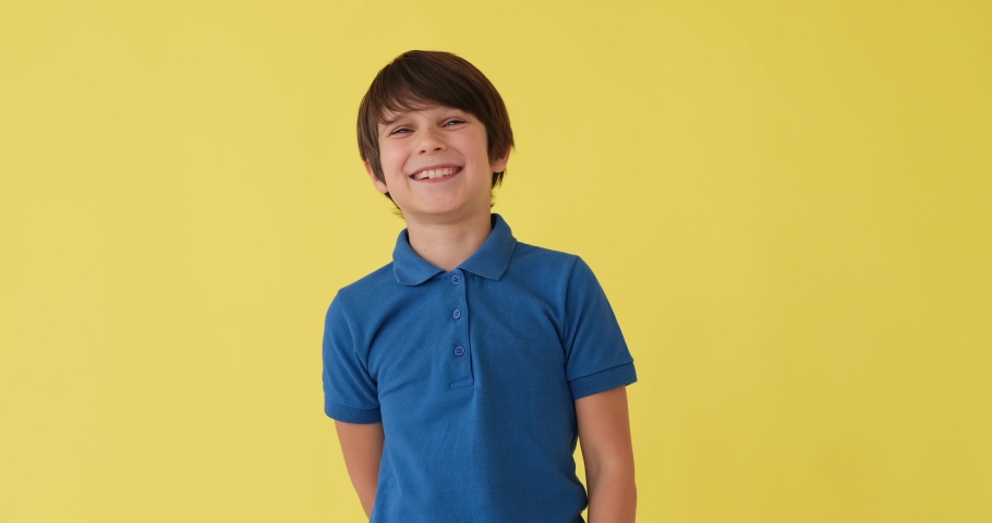 Boy laughing over yellow background