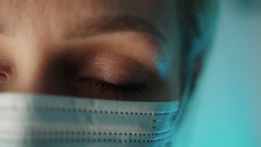 Close up portrait photo. Eye of young female doctor. Protection against contagious disease through wearing hygienic face surgical medical mask. High quality 4k footage Royalty-Free Stock Footage #1088605301