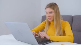 Beautiful blonde woman talking on web camera. Young Ukrainian entrepreneur girl working on laptop and speaking on webcam. Freelancer person doing distant work online