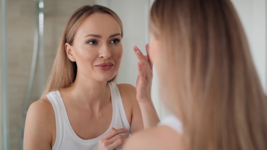 Young woman looking at herself in the mirror in the morning. Shot with RED helium camera in 8K Royalty-Free Stock Footage #1088611877
