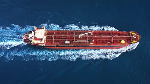 Aerial top down view of a 182 meters long oil chemical tanker ship. Supertanker loaded with full of oil, ploughs through the water. A petroleum tanker underway open sea

