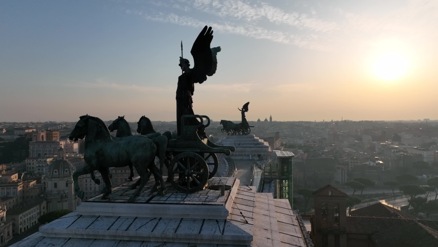 the statue with horses that dominates the Altare della Patria in Rome.
Backlight aerial view on the Roman Forum and Colosseum with the sunrise sun. Royalty-Free Stock Footage #1088616341