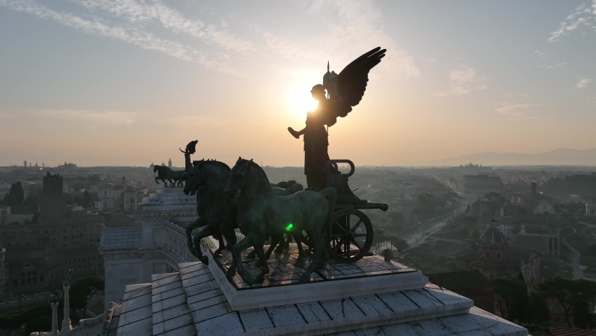 the statue with horses that dominates the Altare della Patria in Rome.
Backlight aerial view on the Roman Forum and Colosseum with the sunrise sun. Royalty-Free Stock Footage #1088616341