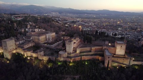 Granada castle of Alhambra after sunset, aerial view of famous Spanish landmark, moorish medieval historic monument in Spain, flying above fortress of Granada at night. High quality 4k footage