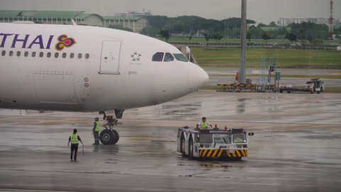 BANGKOK, THAILAND - NOVEMBER 11, 2017: Airbus A330 Thai Airlines and a towing aircraft on an apron at the terminal of Suvarnabhumi Airport, Thailand