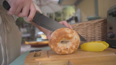 Woman cutting bagel for breakfast