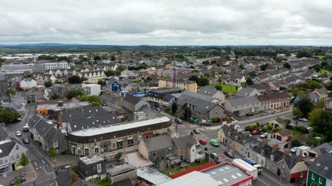 Panorama curve shot of traffic and buildings in town centre. Cathedral with tall spire. Ennis, Ireland