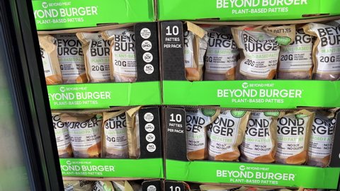 Sacramento CA, USA March 11, 2022 shopper graving a bag of Beyond meat beyond burger meatless burger patties for sale at a local costco discount store