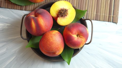 Yellow Peach with slice in metal plate, Fresh Yellow Peach fruit in metal plate on wooden background.