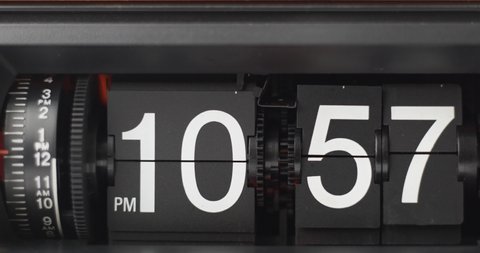 Retro Flip Clock Showing at 10:57 p.m. Spinning on black background.