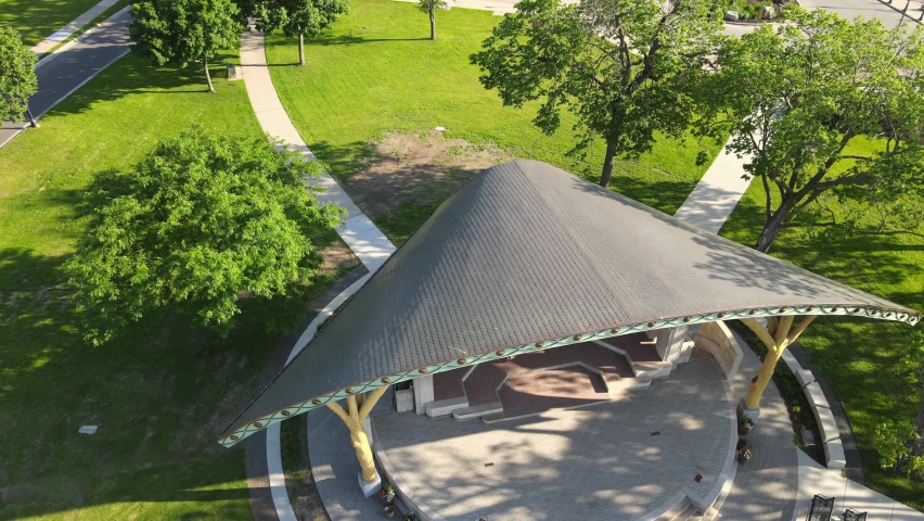 Aerial view of entertainment venue in park in Wisconsin on the Mississippi River. Boats on the river. Office buildings near the park. Blue sky and sun shining creating shadows. 