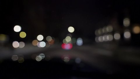 Bokeh of cars and traffic lights at night. Bokeh of small european City Night Traffic. Round colorful bokeh shine from car lights in traffic jam on city street. Slow motion HD footage