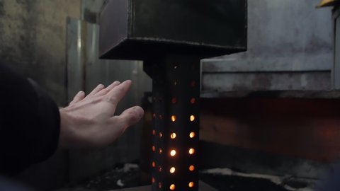 Man warming hands by the flame stove