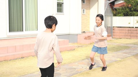 Asian kid playing ball in his yard