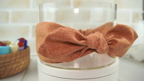 A headband with bow pattern made out of cotton fabric in gold color, great as hair accessories for babies and kids.