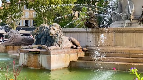 Aix-en-Provence, France - August 2021 : Lions of the Fontaine de la Rotonde fountain in Aix en Provence, France with water flowing in slow motion