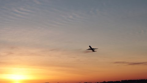 Airplane fly up over take-off in airport at sunrise Passenger flight plane silhouette, dramatic sky. Aircraft departure. International transport flying วิดีโอสต็อก