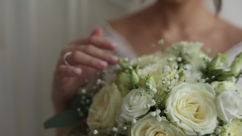 bride's hand with a wedding ring on the bride's bouquet	