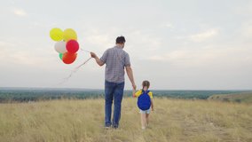 father holds small child with backpack by hand palm. happy family life. multi-colored balloons children's holiday. childhood dream travel with dad. joyful fun day kid. festive mood happy family park - Powered by Shutterstock - Get 15% off with code: PIKWIZARD15