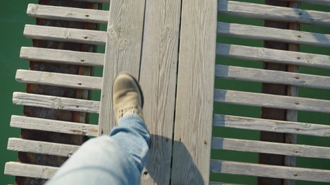 Steps on a wooden pier, first-person view.