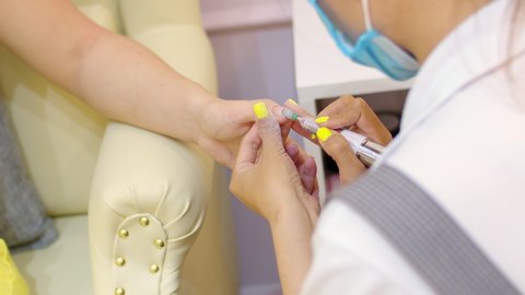 Beautician removes old varnish using manicure machine. Removal of old gel. Manicurist woman removes gel shellac polish from client's nails using manicure machine before the pedicure.