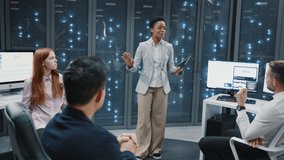 Data center office. Young african businesswoman leading meeting with multi-ethnic staff coworkers. Server room database. Cyber security. Supercomputer. - Powered by Shutterstock - Get 15% off with code: PIKWIZARD15