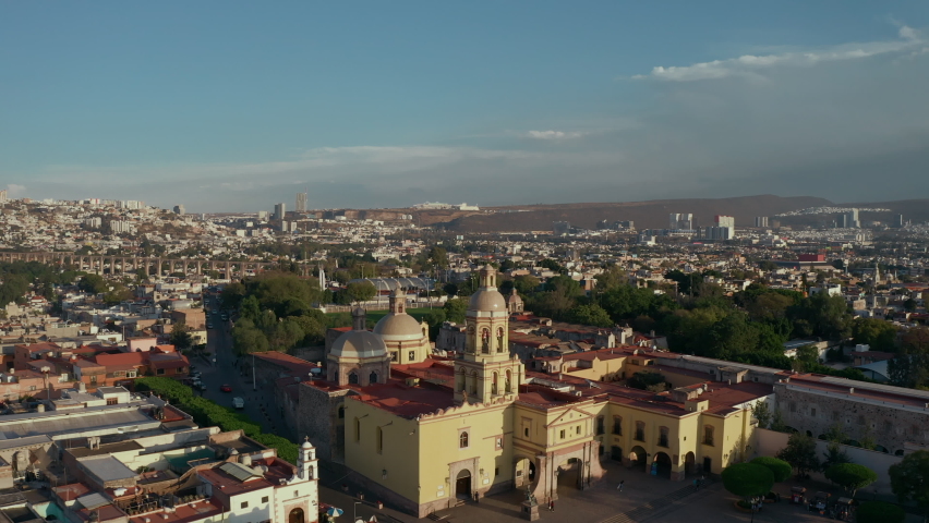 Colonial style city. Center of wine production in Mexico. Aerial drone view of old historical city with cathedral and famous cultural buildings. Sunset time over main tourist destination Queretaro Royalty-Free Stock Footage #1088645427
