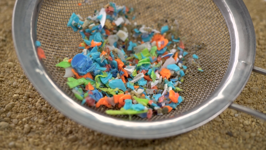 Microplastics hand-picked with a steel sieve from the beach. Concept of global warming and climate change. Non-recyclable plastic pollution in the oceans. | Shutterstock HD Video #1088646287