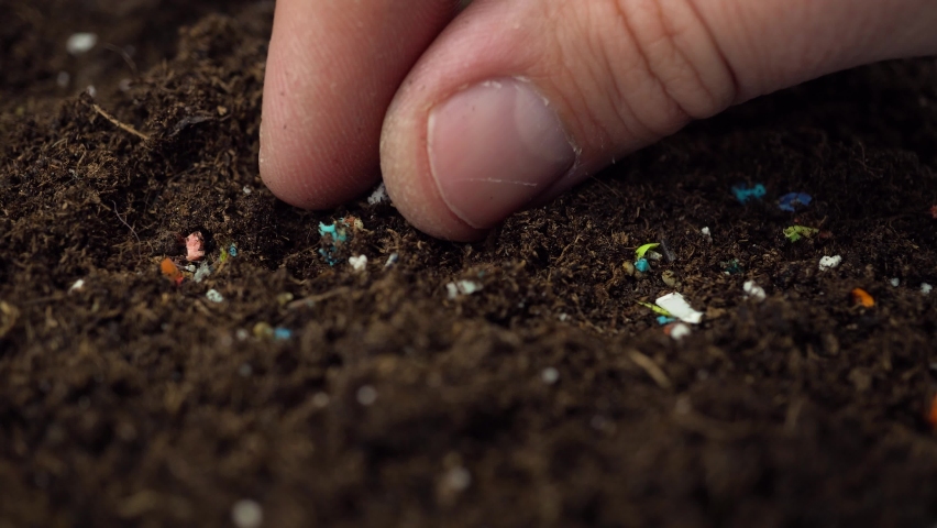 Microplastics inside the soil. Concept of global warming and climate change. Non-recyclable plastic pollution in the soil. Person examining the micro plastics | Shutterstock HD Video #1088646289