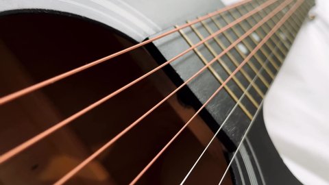 Zoom in shot of black frets fretboard acoustic guitar string. 