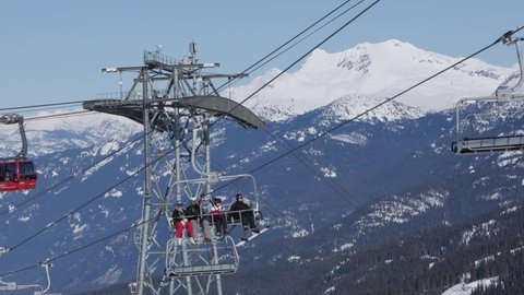 WHISTLER, BC, CANADA - FEB 15, 2022: Whistler Mountain chairlift, ski mountain, sunny day, winter, ski hill. 4k 24fps