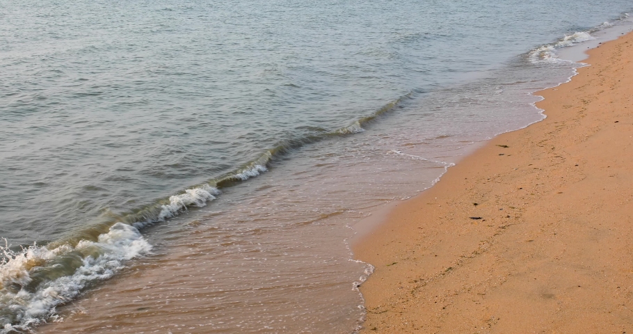 Ocean Waves Along the Sandy Shores of Bangsaray in Pattaya, Thailand. Tilt Medium Shot in 4K.