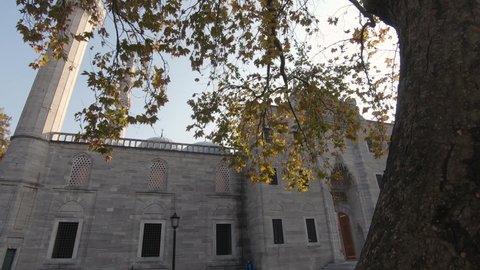 Suleymaniye mosque facade, Slow motion reveal, tree leaves with sunbeams, Ottoman imperial mosque. Istanbul