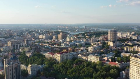 Aerial drone video of downtown skyline buildings and Dnipro river in Pecherskyi district of Kyiv Oblast Ukraine during sunset. Filmed on a summer day in August 2021.