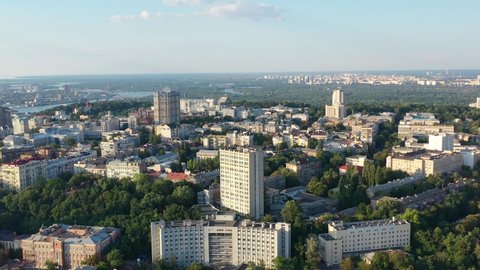 Aerial drone video of downtown skyline buildings and Dnipro river in Pecherskyi district of Kyiv Oblast Ukraine during sunset. Filmed on a summer day in August 2021