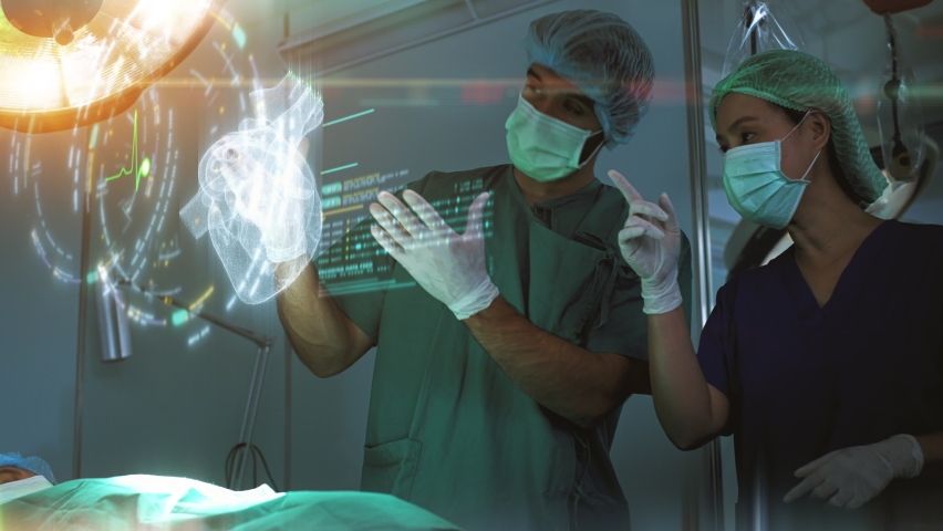 Futuristic simulation operating room - a surgeon diagnosing a senior woman's heart problem via a holographic heart scan simulation before surgical procedure. Concept hospital care Royalty-Free Stock Footage #1088656299