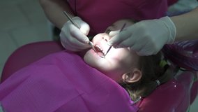 little girl at the dentist at the reception, examination of deciduous teeth for the presence or absence of dental disease.
