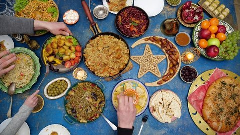Family Ramadan dinner. Muslim people gathering to break their fast together. Traditional Dishes to Serve During Ramadan. A people sitting at a table, top view