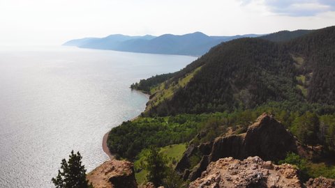 Beautiful view from the cliff, mountains to Lake Baikal on a sunny summer day. Aerial view.