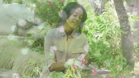 Animation of glowing spots over happy biracial couple with watering can gardening. gardening and community garden week concept digitally generated video. - Powered by Shutterstock - Get 15% off with code: PIKWIZARD15