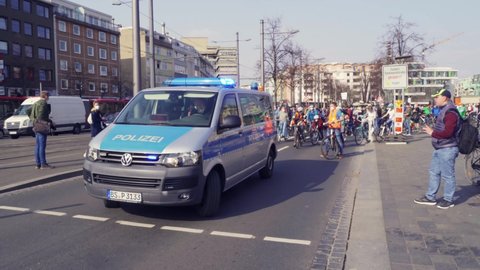 Braunschweig, Germany, March 25, 2022: Police car with a black uniformed policeman leads the bicycle demonstration for the global climate strike