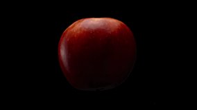 Close-up, red apple on a black background in rotational motion