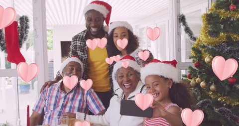 Animation of heart icons over african american family with santa hats. social media and communication interface concept digitally generated video.
