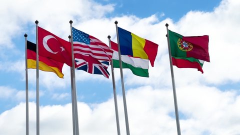 Natural video Flags of Germany, Turkey, Britain, USA, Hungary, Romania, Bulgaria, Portugal against a blue sky. 