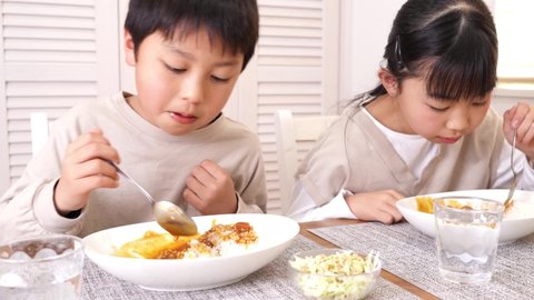 Asian kids eating curry rice