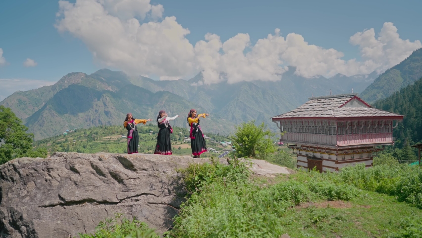 Young beautiful cheerful Indian Asian Women or females wearing traditional attire dancing outdoors with a background of Mountainous valley in daylight. Concept of customs, music, culture, traditions | Shutterstock HD Video #1088671107