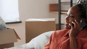 moving, people and real estate concept - happy smiling woman with boxes calling on smartphone at new home - Powered by Shutterstock - Get 15% off with code: PIKWIZARD15