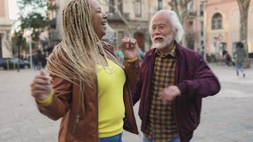 Happy diverse senior friends having fun dancing in city - Joyful elderly people concept - Powered by Shutterstock - Get 15% off with code: PIKWIZARD15