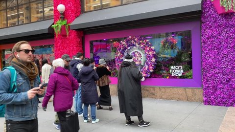 New York NY USA-March 27, 2022 Visitors outside of Macy's flagship department store in Herald Square in New York which is festooned with floral arrangements for the annual Macy's Flower Show