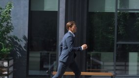 Confident businessman late for meeting running downtown street in sunny morning. Focused handsome project manager director going to important client in hurry. Serious agent rushing to office in suit. - Powered by Shutterstock - Get 15% off with code: PIKWIZARD15